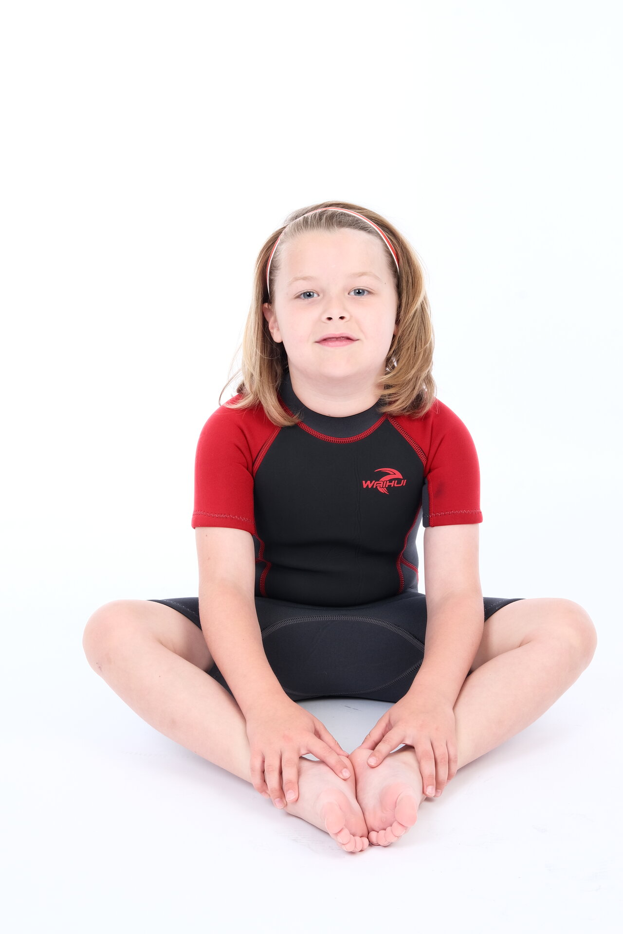 George Rouse in red and black athletic wear, sitting athletic pose demonstrating strength and confidence